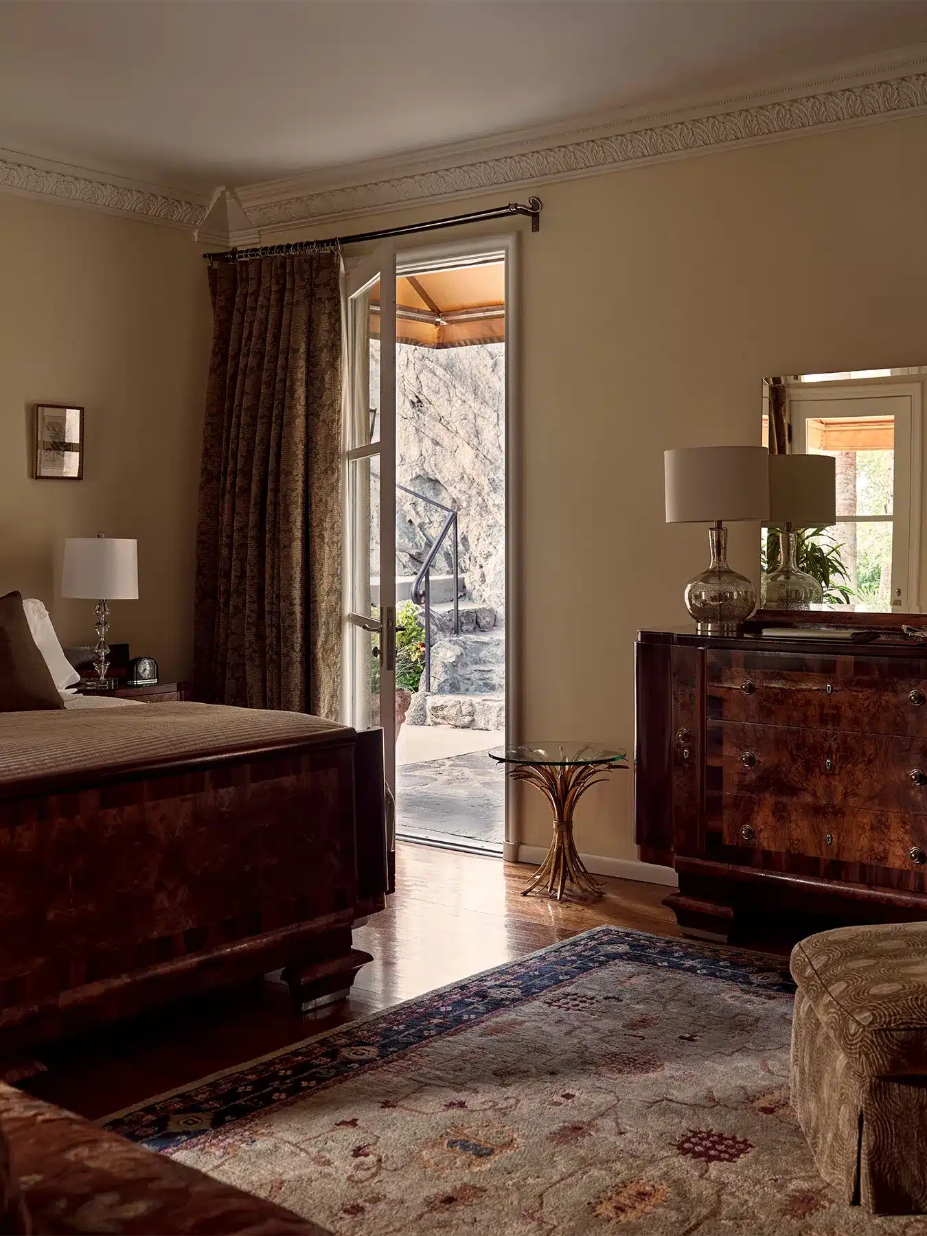 Einstein room with bed, dresser, chair, and open door leading to patio