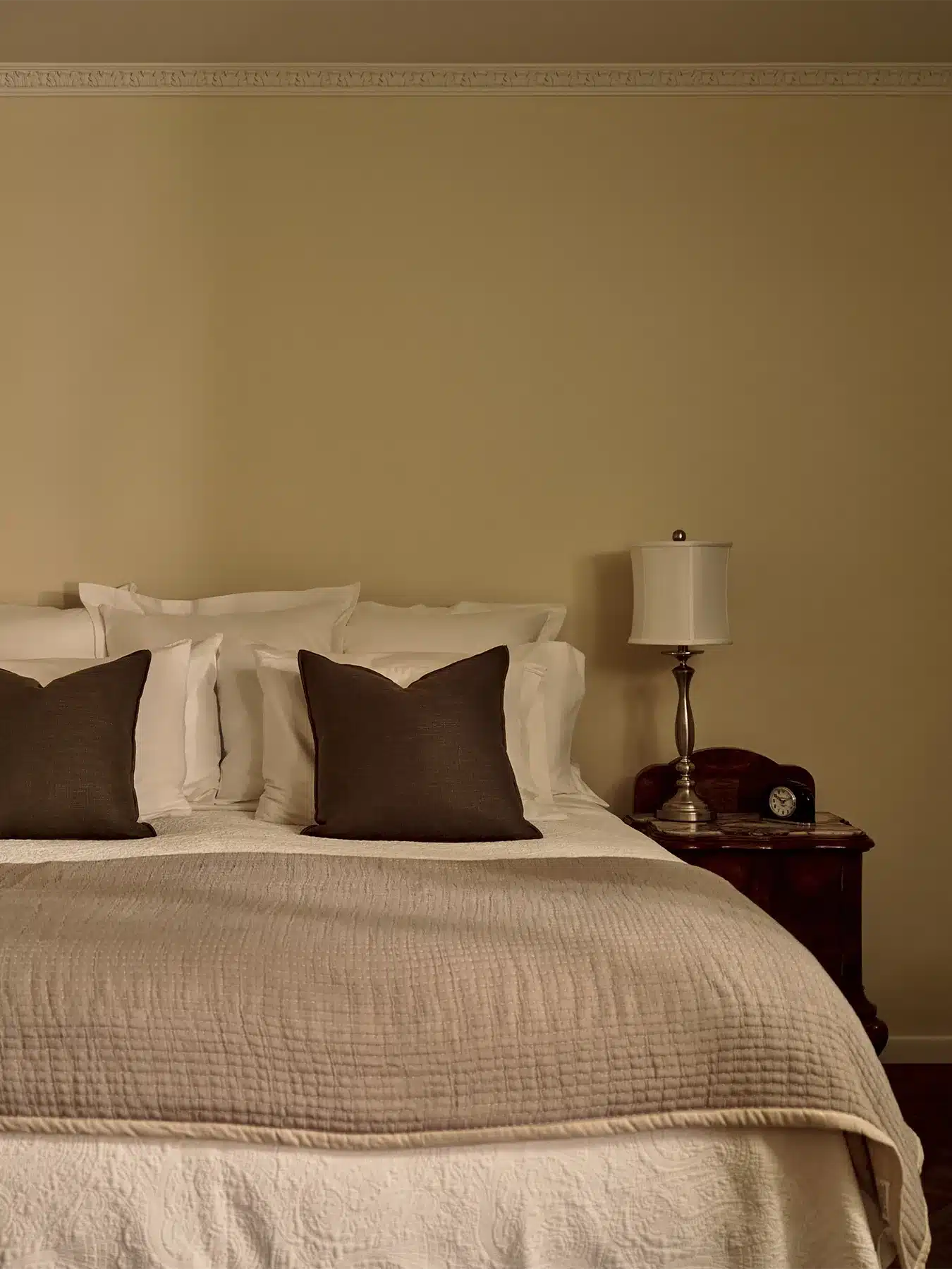 Rock room bed with side table, lamp, and clock