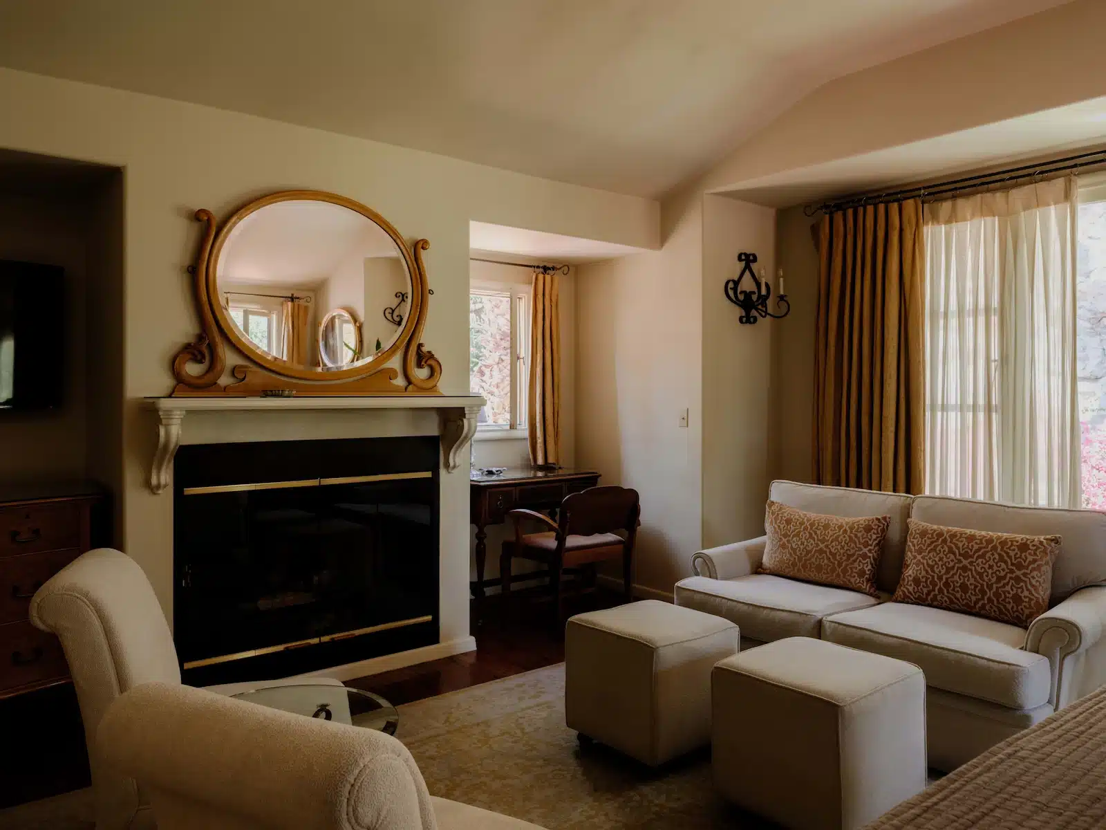 Waterfall sitting area with two chairs, couch, tables, and a fireplace