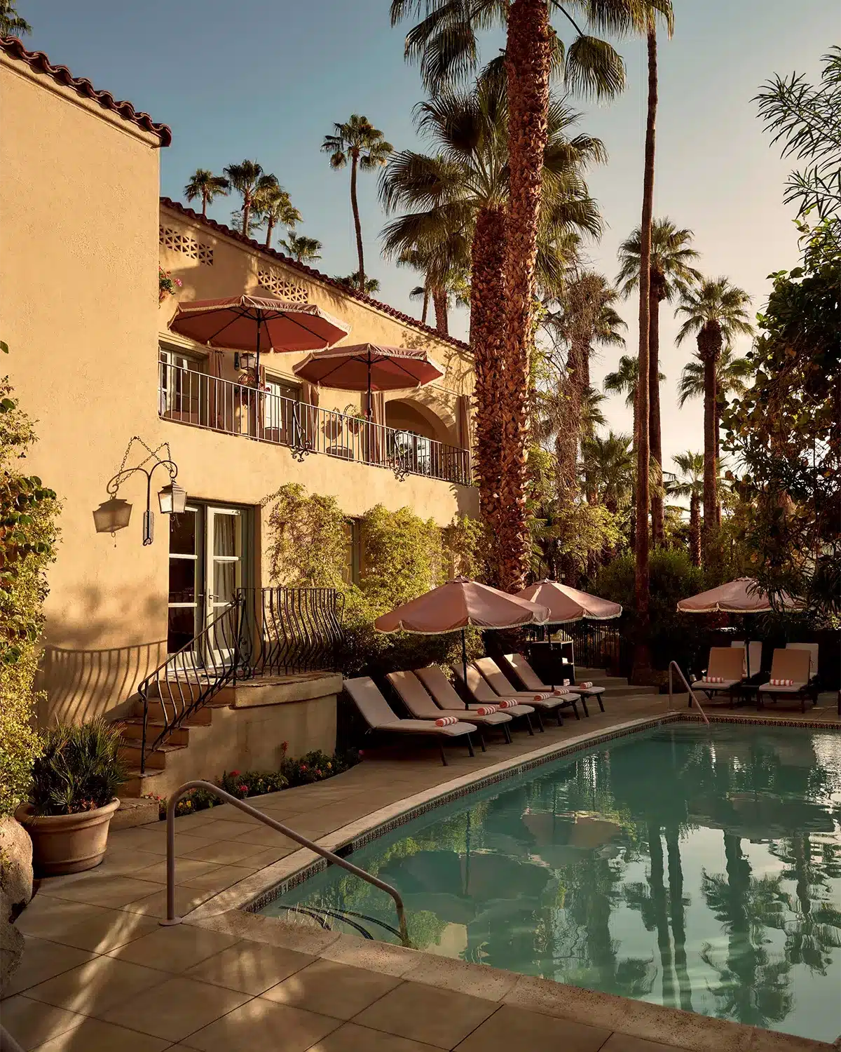 Exterior pool with reclining seating and shade umbrellas